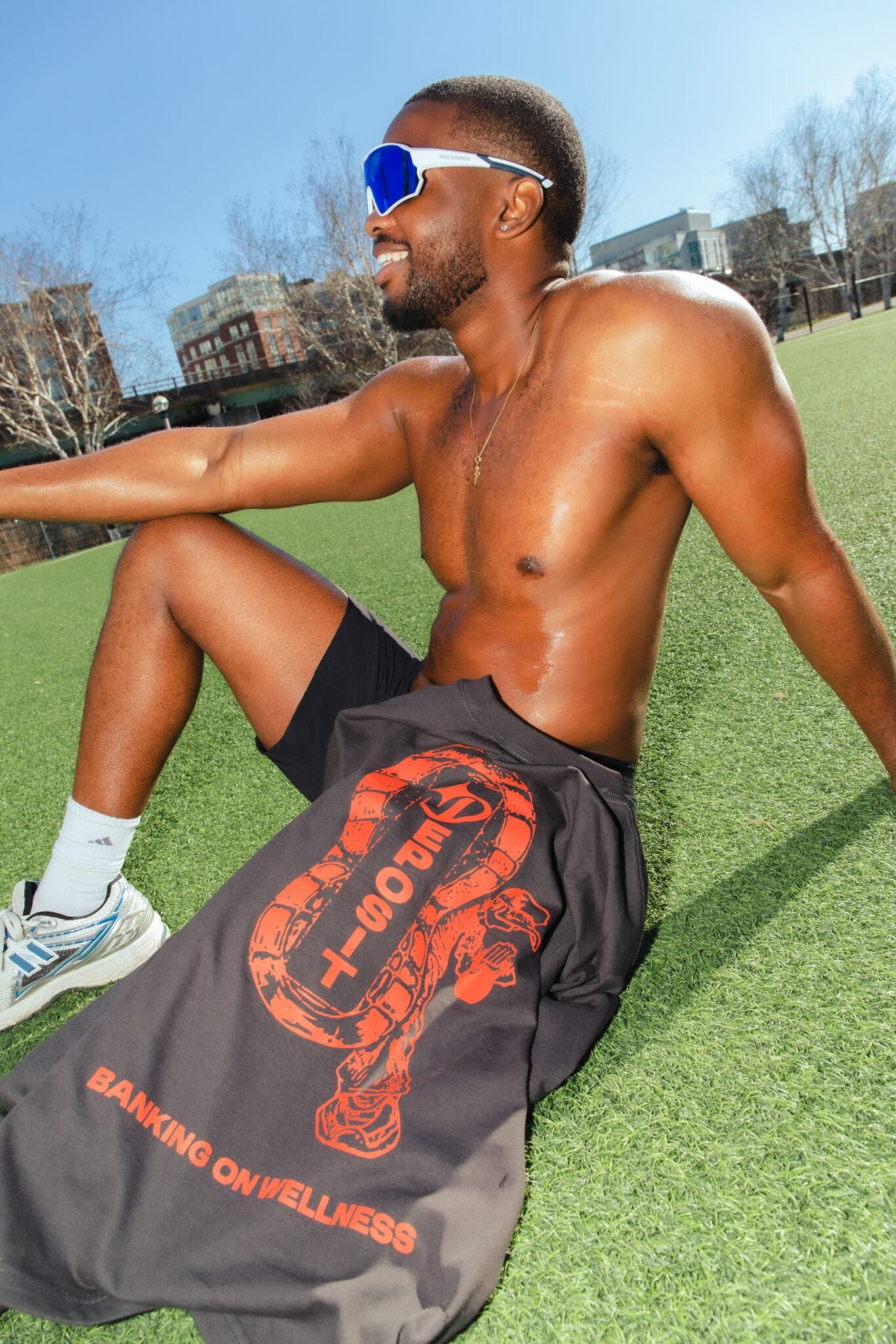 Athlete sitting with the Banking on Wellness graphic tee against the Toronto skyline.